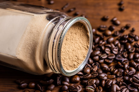 Coffee beans and ground coffee in a glass jar on wooden backgroundの写真素材