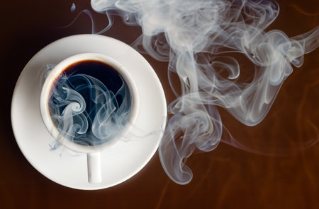 Cup of coffee with smoke on brown background, top view.の写真素材