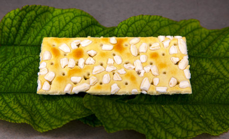Crispy cracker with sesame seeds on a green leafの写真素材