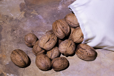Walnuts in a sack on a wooden background. Selective focus.の写真素材