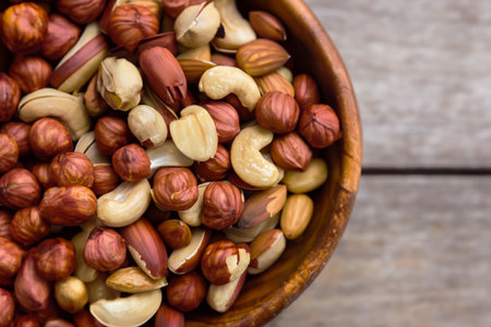 Mix of nuts in wooden bowl on wooden background. Top views.の写真素材