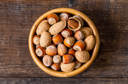 Assortment of nuts in wooden bowl on wooden background. Top views.
