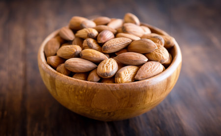 Almond nuts in a wooden bowl on a wooden background. Selective focus.の写真素材