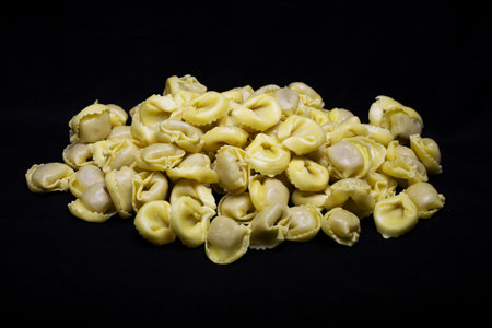 Tortellini pasta on a black background. Toned.の写真素材