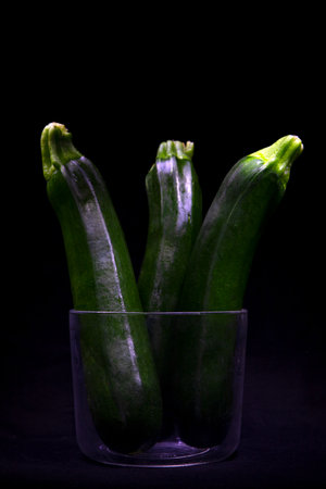 Zucchini in a glass on a black background. Studio photography.の写真素材