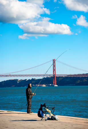 Fisherman on the embankment of the Tagus river in Lisbon, Portugalの写真素材