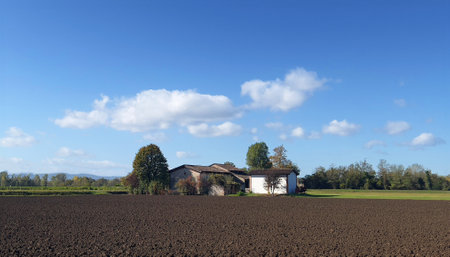 farm in the countryside with blue sky and white clouds in the backgroundの写真素材