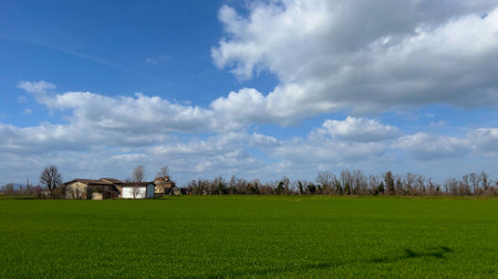 Rural landscape with a farm house and green field in spring.の写真素材