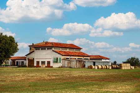 Old farmhouse in the countryside, Romania. Rural landscape with hay bales.の写真素材