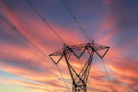 High-voltage power lines at sunset. Electricity distribution station.