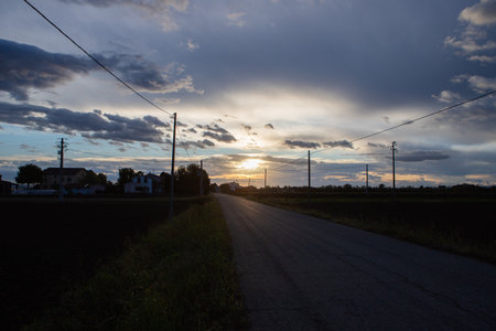 Sunset over a rural road in the countryside in the evening.の写真素材