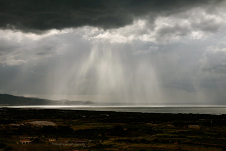 Stormy sky with rain and rainclouds over the sea.の写真素材