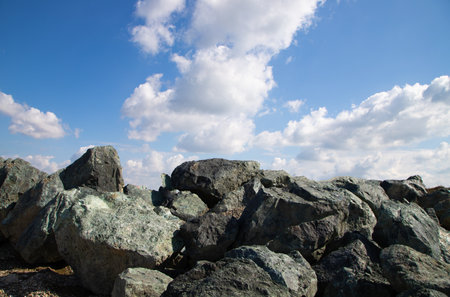 Rocky hillside with blue sky and white clouds in the backgroundの写真素材