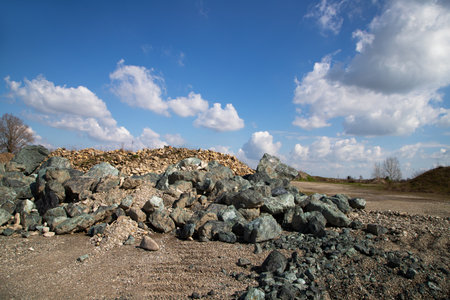 Pile of stones on the ground against the blue sky with cloudsの写真素材