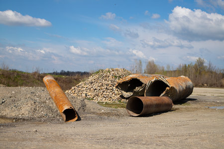 old rusty pipes on the background of a blue sky with white cloudsの写真素材