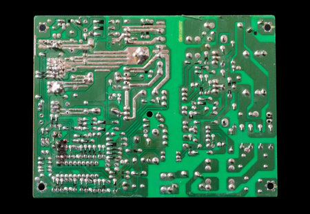 Green printed circuit board isolated on black background. Close-up.