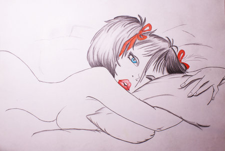 Young woman in bed with a book in her hand, drawing on paperの写真素材
