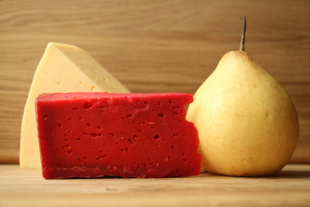 Red cheese and cream cheese on a wooden table together with pears.の写真素材
