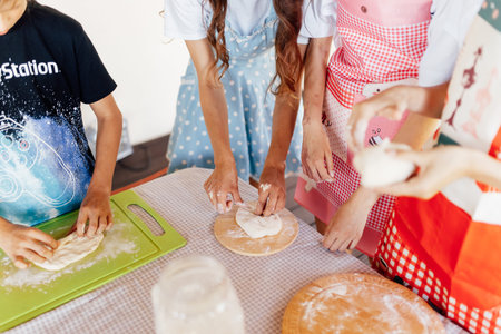 Group of children cooking . Kids wearing colorful aprons baking dessert at home.