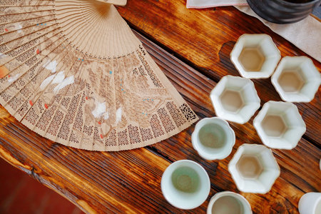 Mugs for a tea ceremony with a fan on a wooden table top view