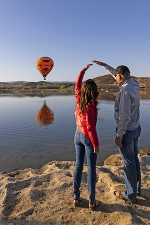 Balloon launch at California lake with couple viewingの写真素材