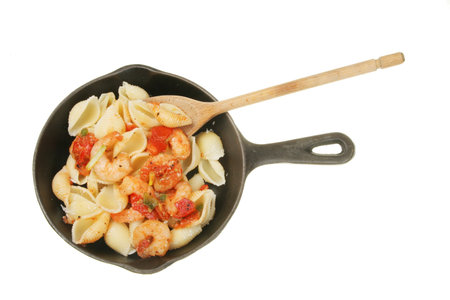 Prawns and pasta in a pan with a wooden spoonの写真素材