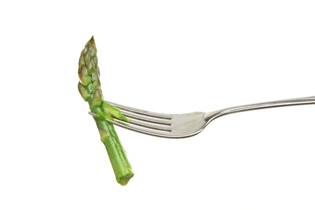 Spear of cooked asparagus on a fork isolated against whiteの写真素材