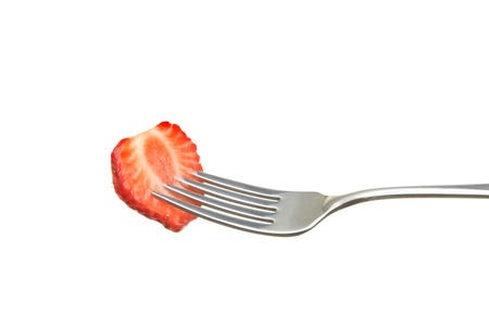 Cut strawberry on a fork isolated against whiteの写真素材