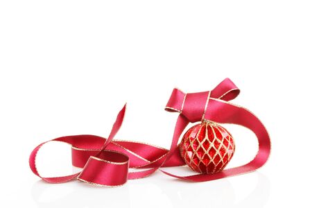 Red and gold Christmas bauble with a red bow and ribbon with soft shadows against whiteの写真素材