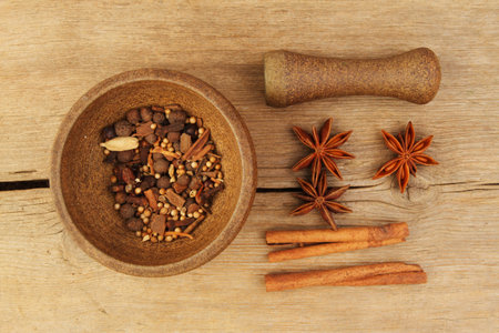 Spices, star anise and cinnamon with a pestle and mortar on old weathered wood