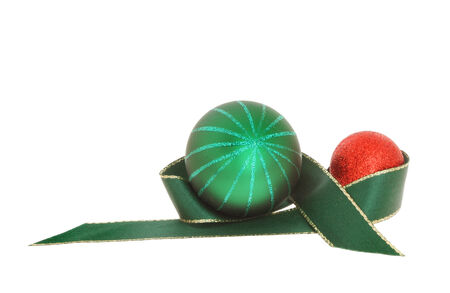 Christmas decoration green ribbon with red and green baubles isolated against whiteの写真素材