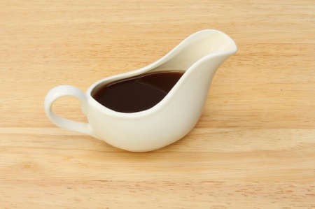 china gravy boat on a wooden boardの写真素材