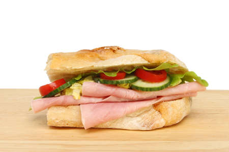 Ham salad ciabatta roll on a wooden board against a white backgroundの写真素材