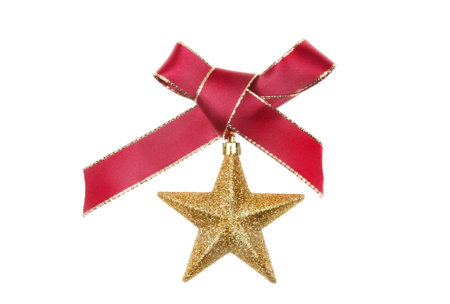 Christmas decoration of red ribbon bow and a gold glitter star isolated against white