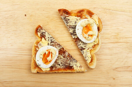 Hard boiled egg on toast on a wooden boardの写真素材