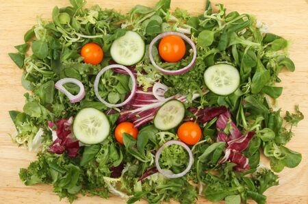 Mixed salad on a wooden board viewed from aboveの写真素材