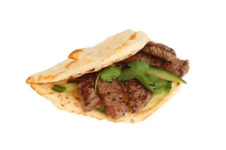 Steak cucumber and coriander in a flatbread isolated against whiteの写真素材