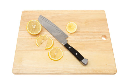 Cut lemon and a knife on a wooden chopping board isolated against whiteの写真素材