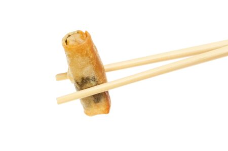 Spring roll held in chopsticks isolated against whiteの写真素材