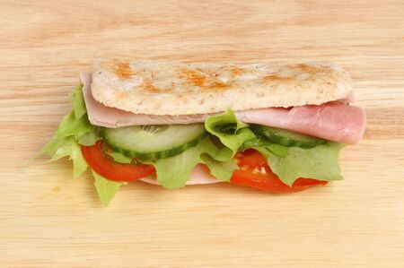 Ham salad sandwich thin wrap on a wooden boardの写真素材