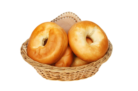 Bagels with a serviette in a wicker basket isolated against whiteの写真素材