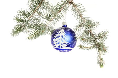 Snow scene Christmas bauble hanging in a snow dusted conifer branch against a white backgroundの写真素材