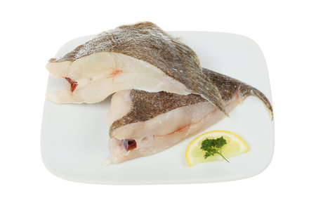 Two raw brill fish cutlets on a plate isolated against white