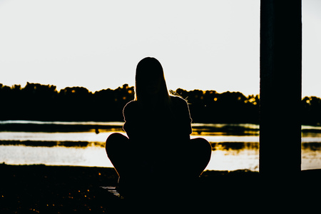 Teenage girl on the beach enjoying the sunset, relaxes and meditatesの写真素材