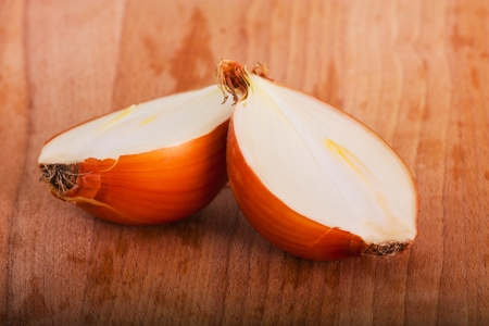 two halves of yellow onion on a wooden boardの写真素材