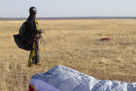 A male paraglider pilot right after landingの写真素材