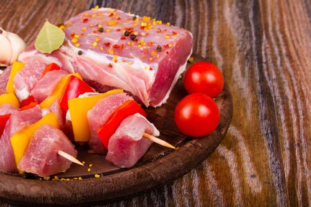 Raw fresh meat on cutting board with condiments and fresh vegetablesの写真素材
