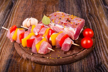 Raw fresh meat on cutting board with condiments and fresh vegetablesの写真素材