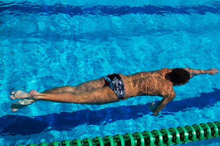 Professional swimmer dives under water in the pool - Stock Image