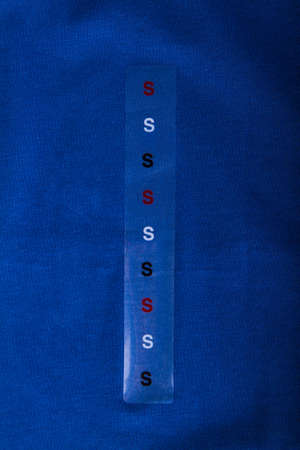Label size S on blue cloth - Stock Imageの写真素材